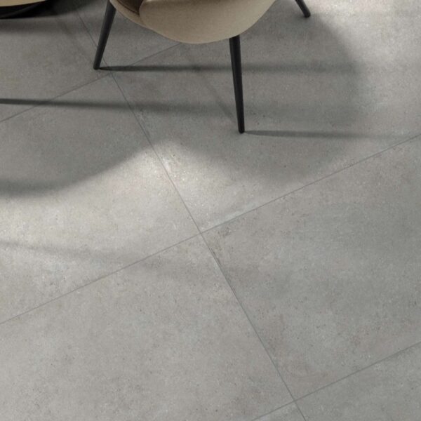 Carrelage effet béton, Concrete Atelier chez Piastrella - salle à manger, fauteuil beige et table basse noire
