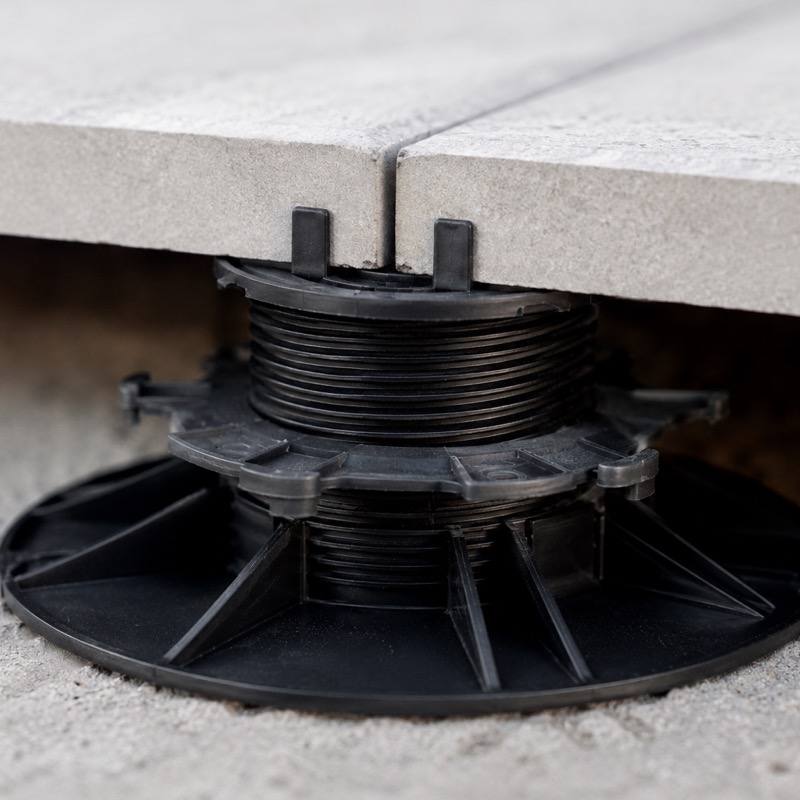 Carrelage sur plots : avantages et inconvénients 1 Détail d'un plot réglable en polypropylène sous une dalle de carrelage grès cérame posée sur plots