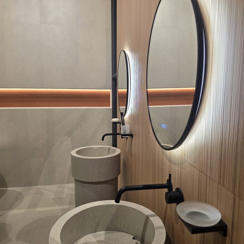 Cersaie 2026 : les tendances carrelage 2027 repérées à Bologne 2 Cersaie 2026, tendances carrelage 2027 chez Piastrella - mur effet bois noyer derrière une vasque en pierre